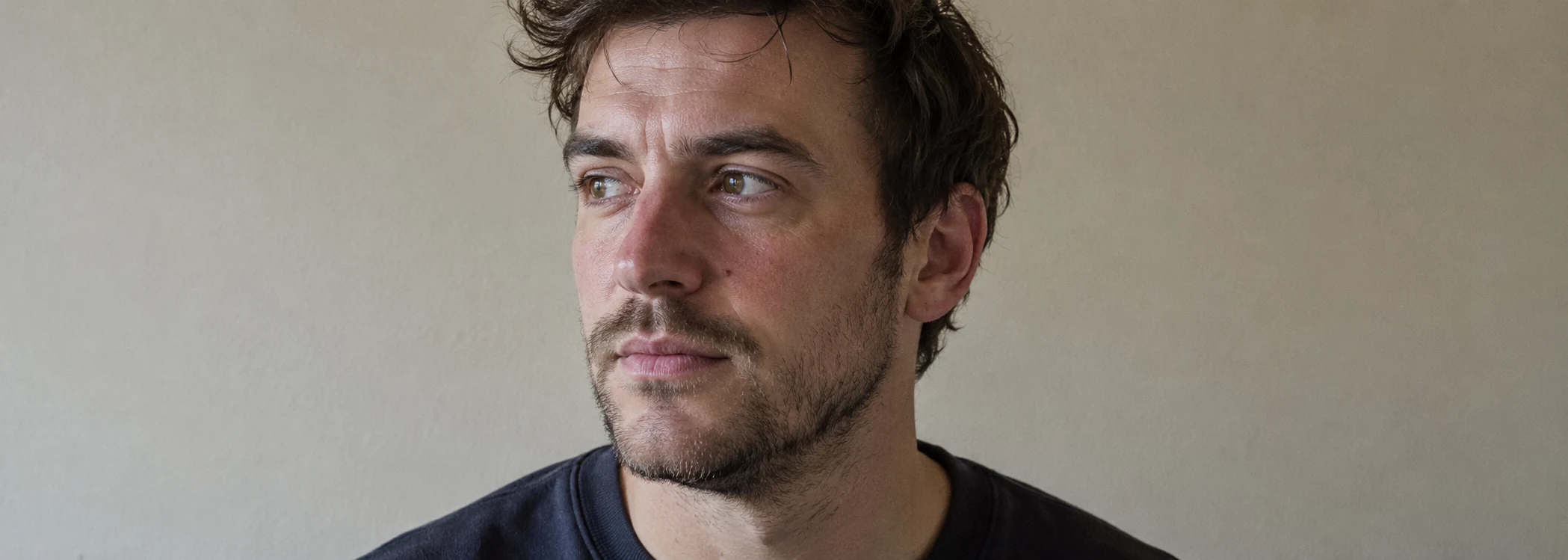 A man in his thirties looking away from the camera